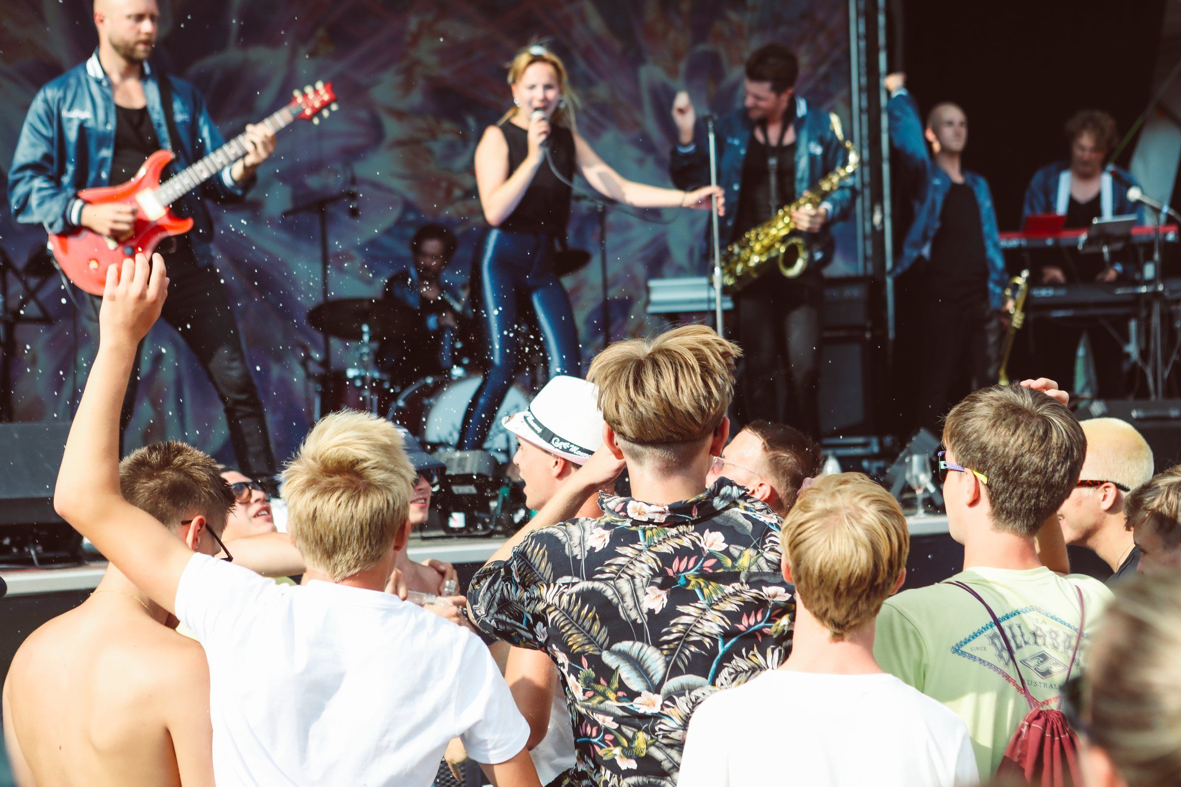 Sångerskan, gitarristen och saxofonisten längst fram på scenen