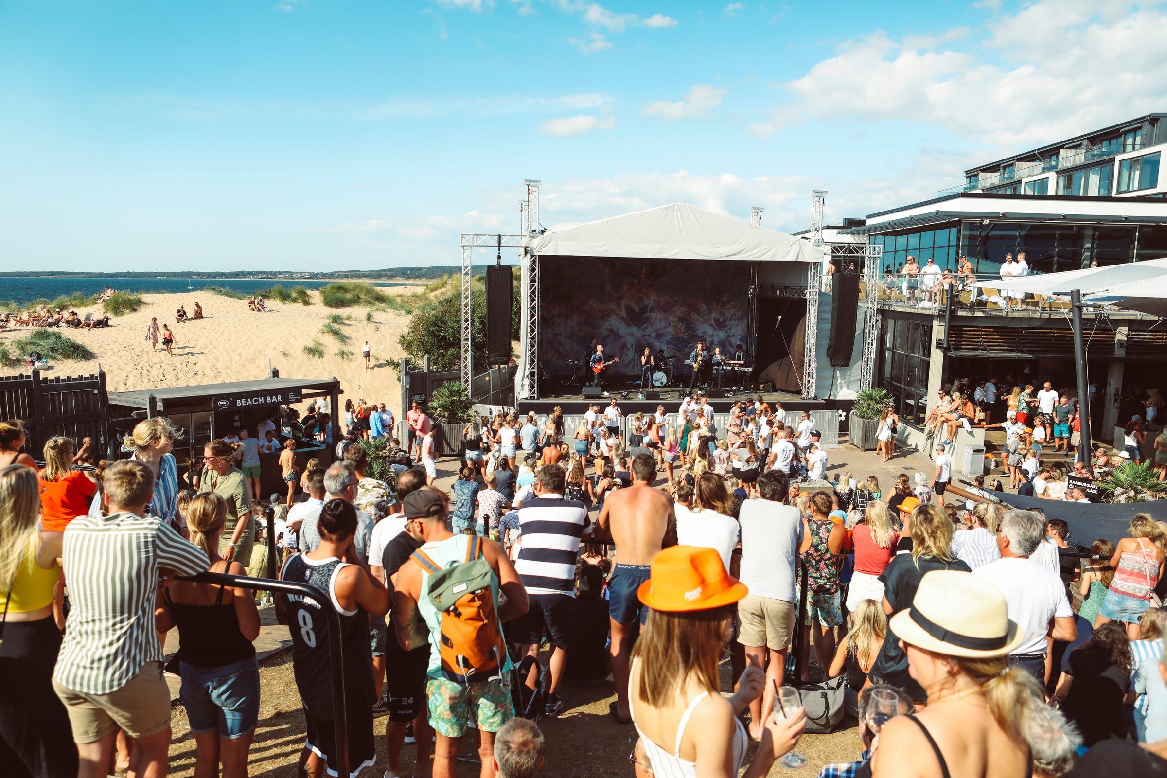 Publiken dansar framför scenen vid stranden